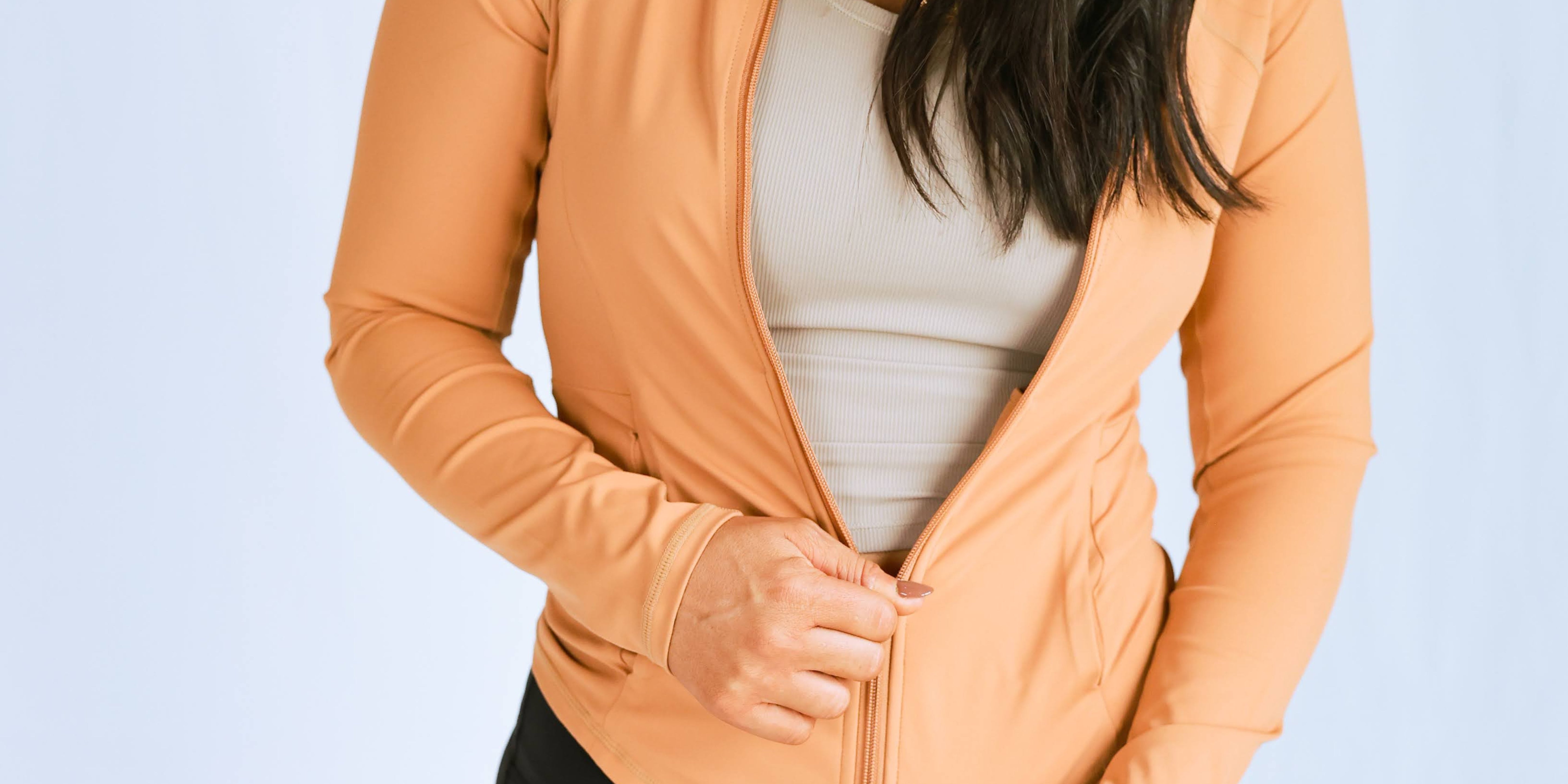 Model wearing the "smooth" fitted jacket from The Sweat Society. She is wearing the orange color. 