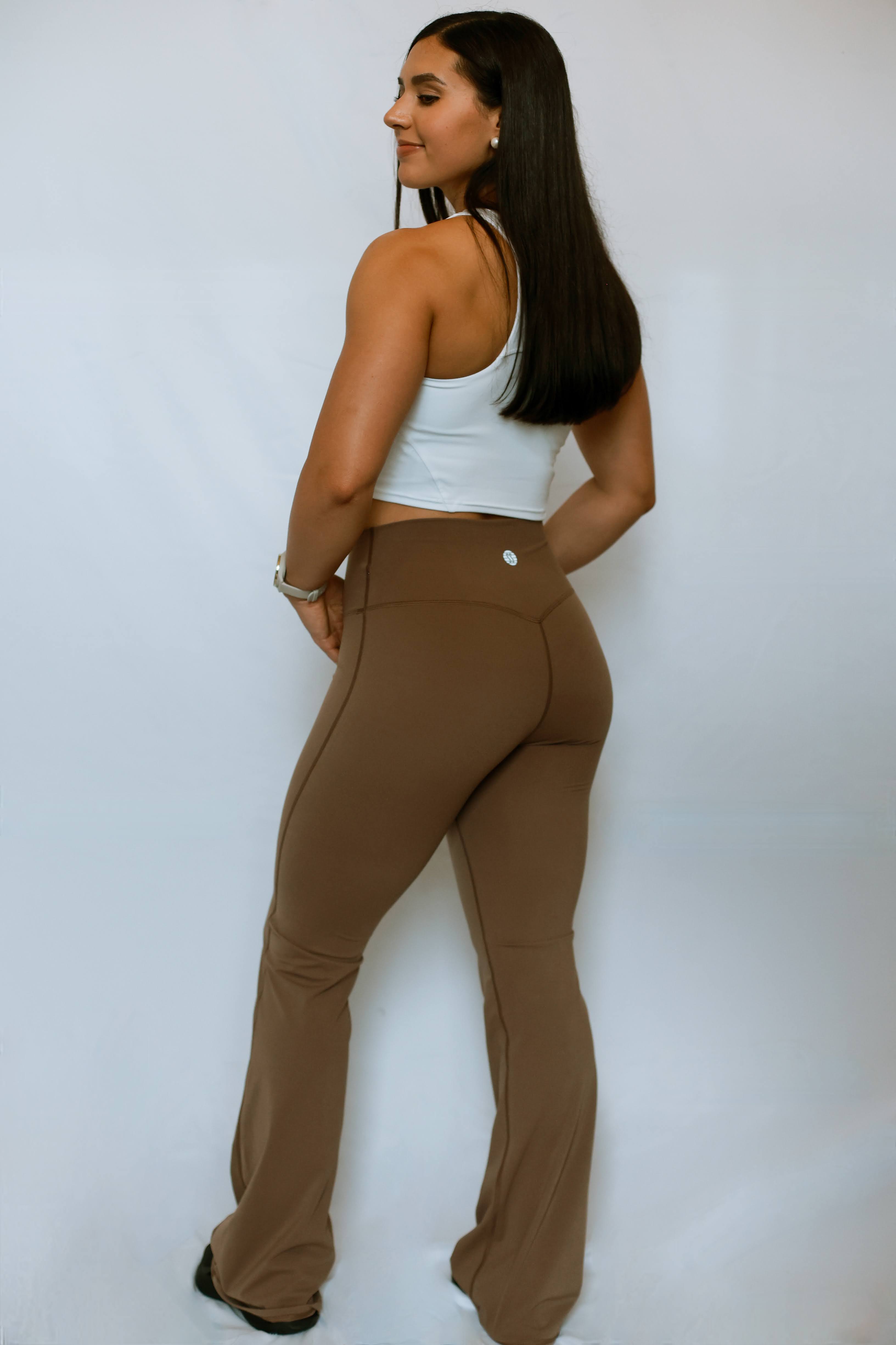 Model turned to the side showing the backside design of the soft yoga flared pants from The Sweat Society.